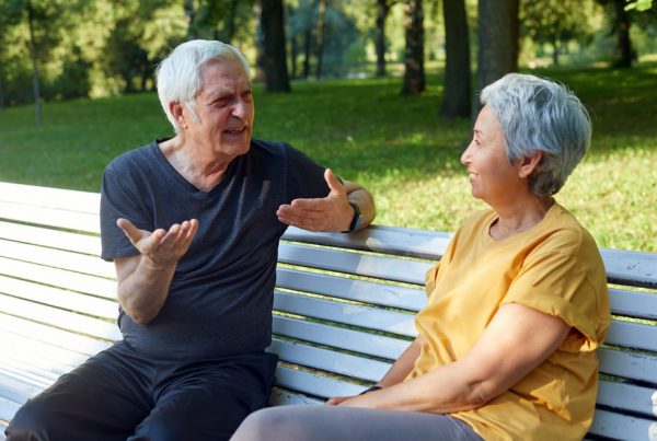 Due senior parlano e si ascoltano seduti su una panchina