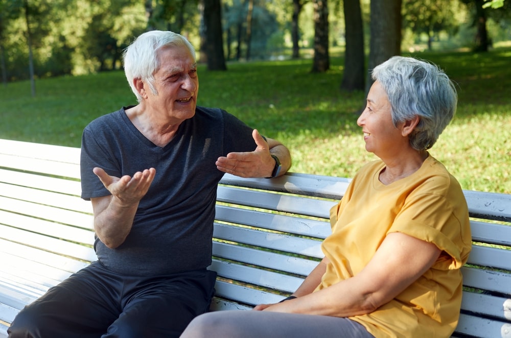 Due senior parlano e si ascoltano seduti su una panchina